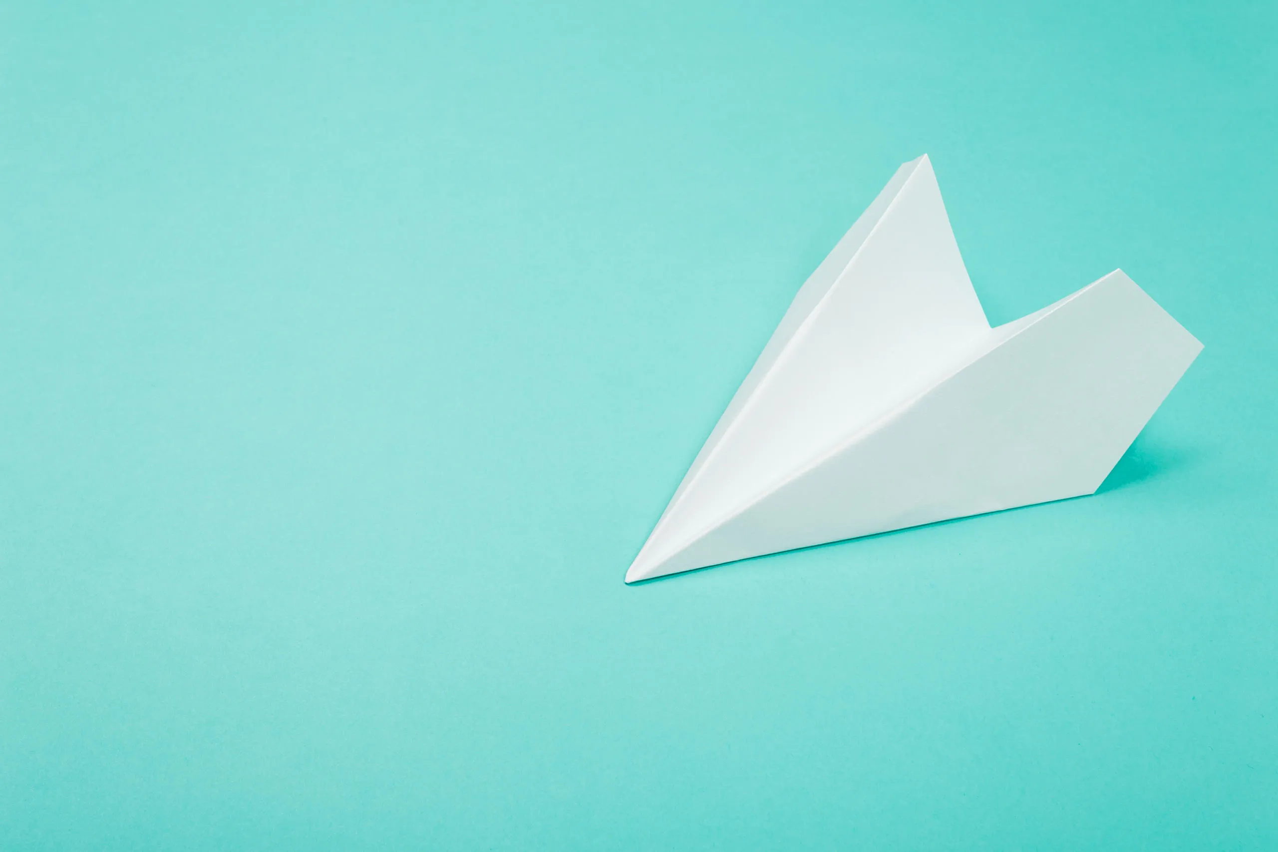 A paper aeroplane on a blue background