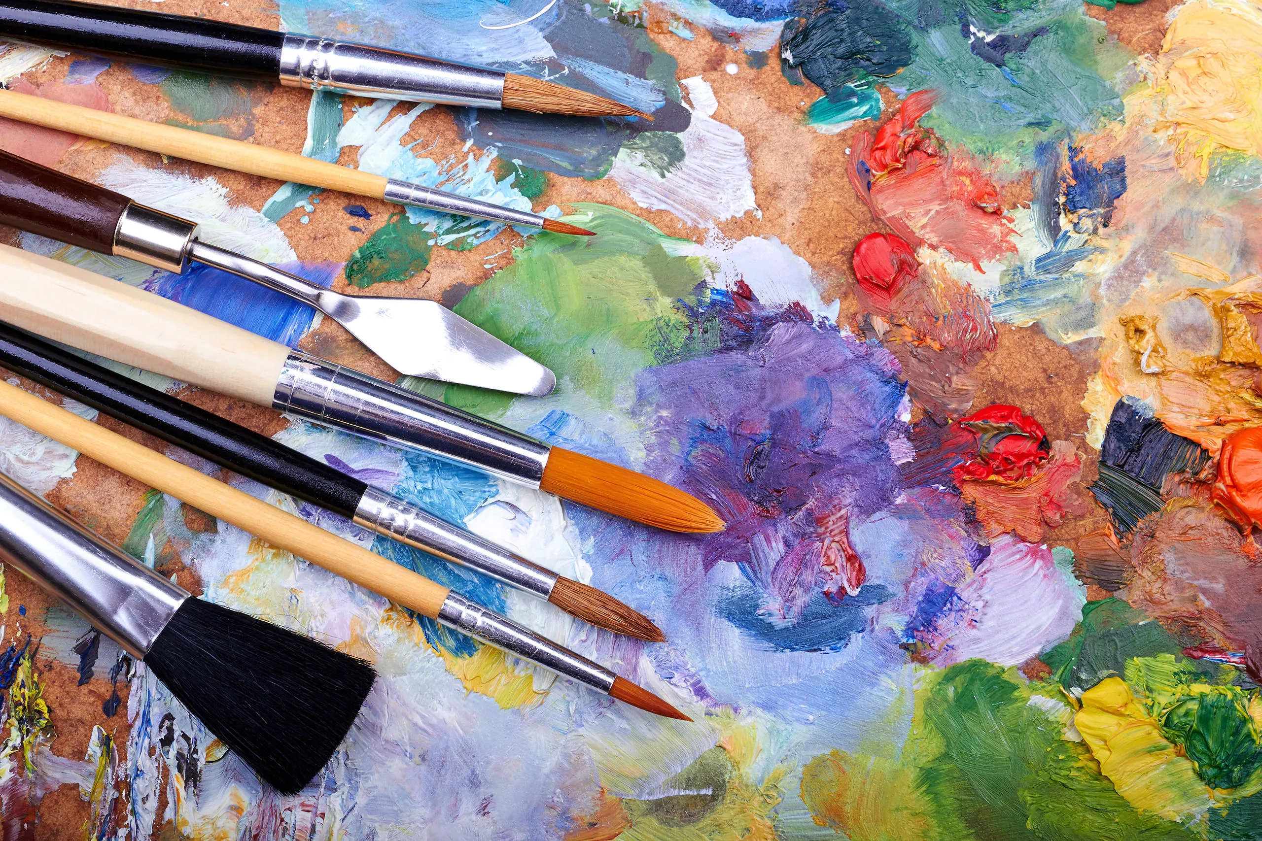 Art brushes against a colourful palette board